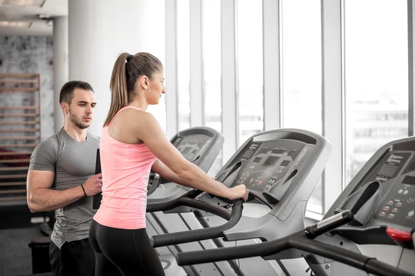 Treadmill walk with personal trainer. — Stock Photo, Image