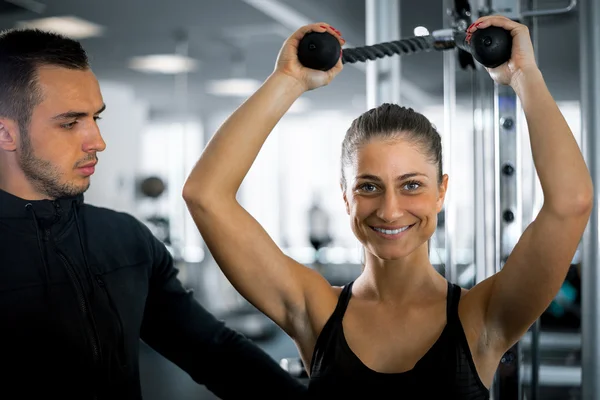 Osobní fitness trenér s jeho klientem v tělocvičně. — Stock fotografie