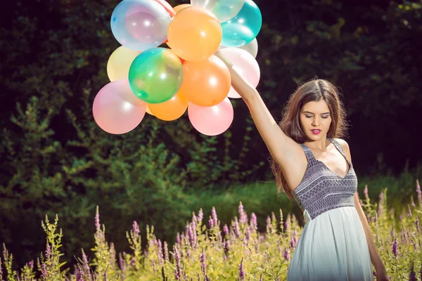 Chica sosteniendo globos en la mano —  Fotos de Stock