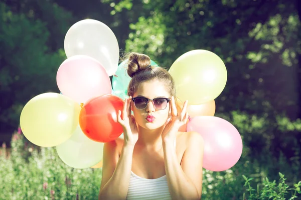 Meisje poseren met ballonnen in de natuur — Stockfoto