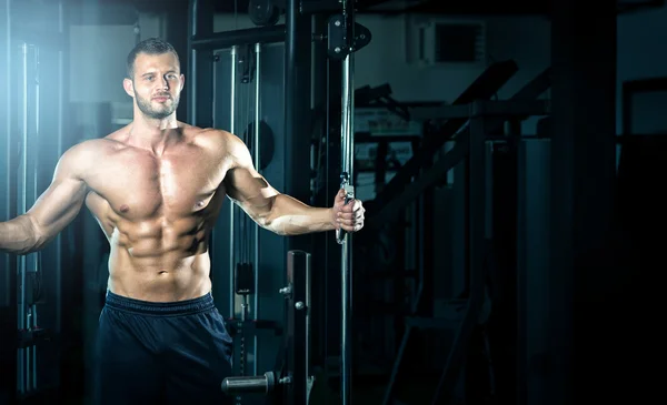 Hombre haciendo volar cable en el gimnasio — Foto de Stock