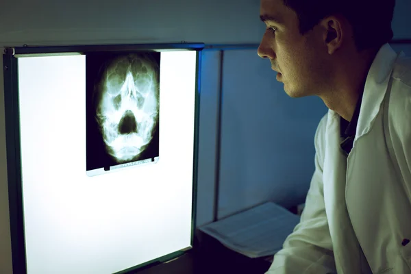 Junge Ärztin schaut sich Röntgenbild an — Stockfoto