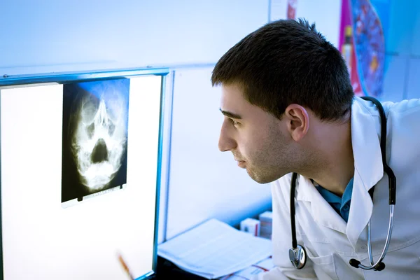 Junge Ärztin schaut sich Röntgenbild an — Stockfoto