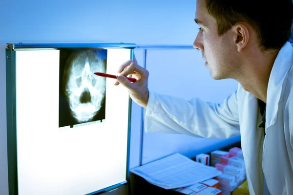 Young doctor looking at X-ray — Stock Photo, Image
