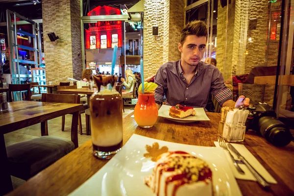 Junger Mann sitzt im Café — Stockfoto