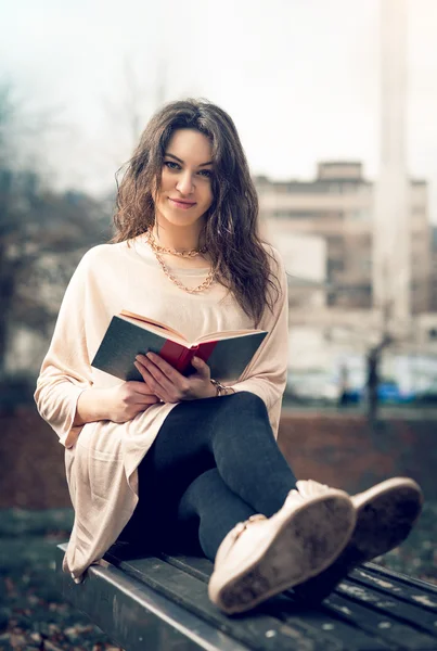 Fille lisant un livre dans le parc — Photo