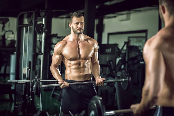 Spor salonunda ağırlık kaldıran bir adam. — Stok fotoğraf