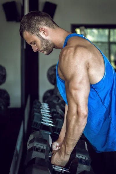 Człowiek robi biceps loki w siłowni — Zdjęcie stockowe