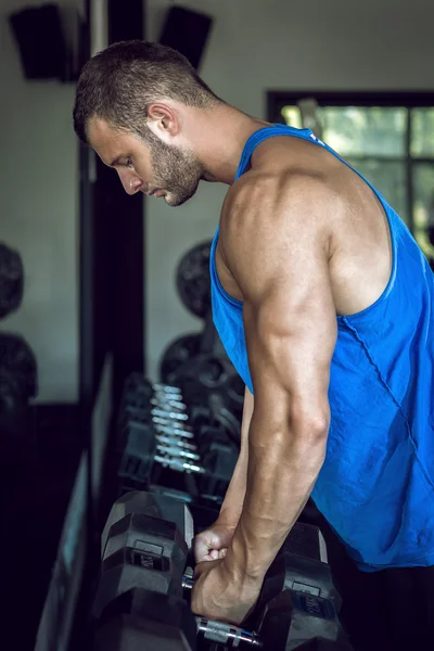 Hombre haciendo bicep rizos en el gimnasio — Foto de Stock