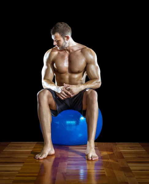 Hombre sentado en la pelota de gimnasio —  Fotos de Stock