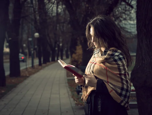 Fille lisant un livre dans le parc — Photo