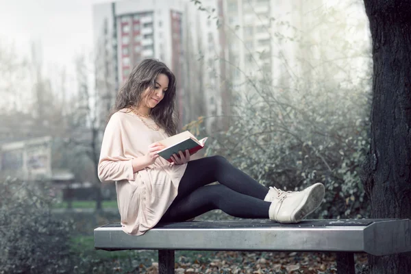 Fille lisant un livre dans le parc — Photo