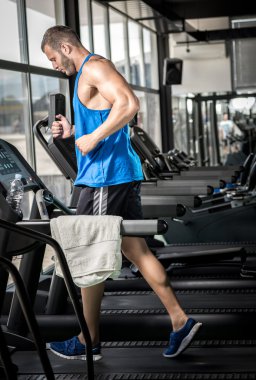 spor salonunda treadmill çalışan genç adam