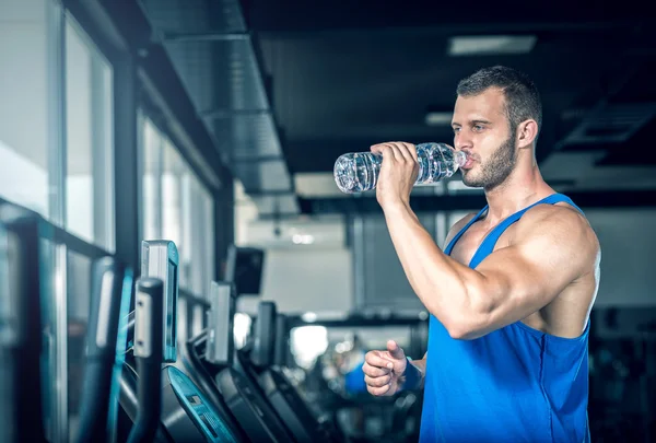 Ung man dricksvatten i gym — Stockfoto