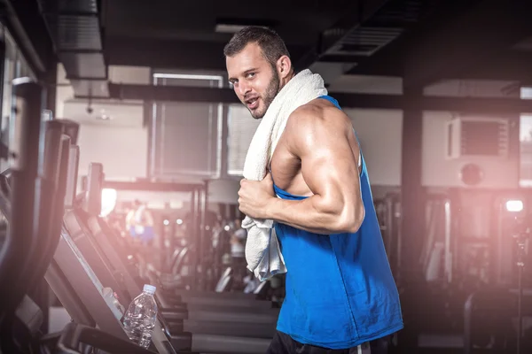 Jeune homme courant au tapis roulant dans la salle de gym — Photo