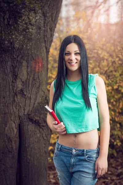 Fille dans parc holding livre — Photo