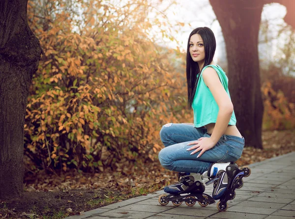 ローラー スケートの上にひざまずく少女. — ストック写真