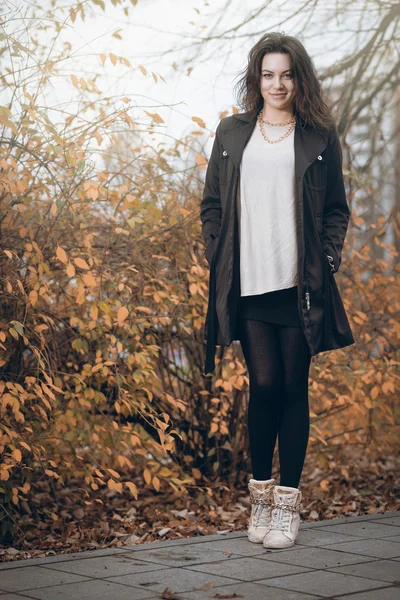 Kız parkta sonbaharda siyah paltolu. — Stok fotoğraf