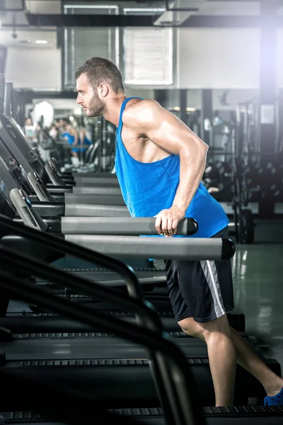 Young man running at treadmill in gym — Stock Photo, Image