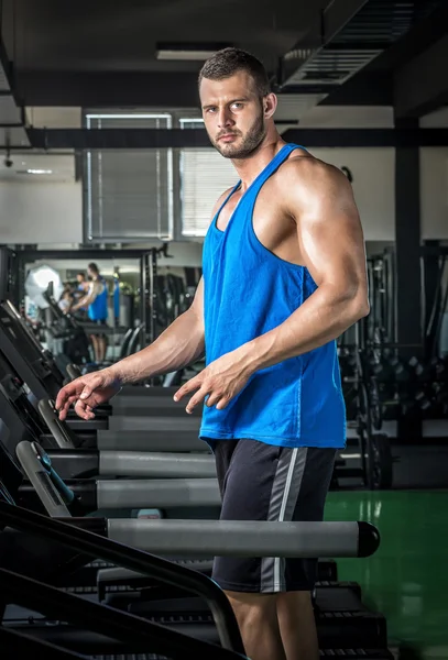 Jeune homme courant au tapis roulant dans la salle de gym — Photo