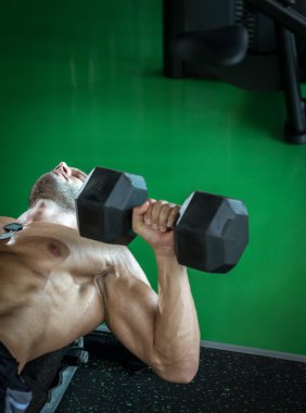 Dumbbell basın yatarken yapan erkek