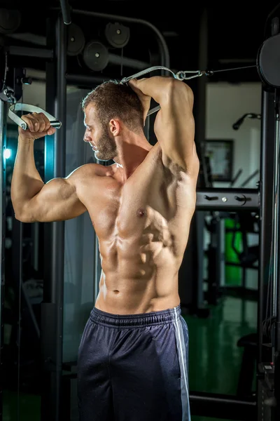 Hombre haciendo volar cable en el gimnasio — Foto de Stock