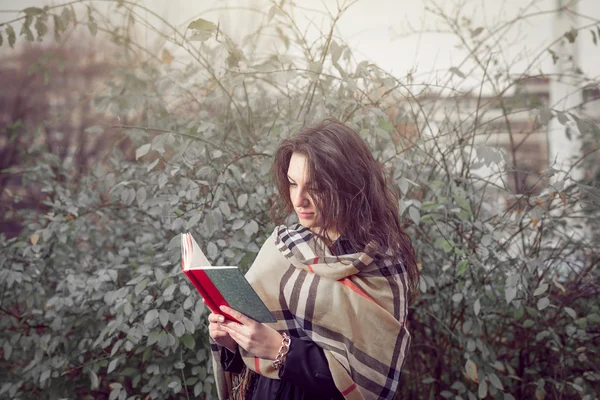 Flicka som läser en bok i parken — Stockfoto