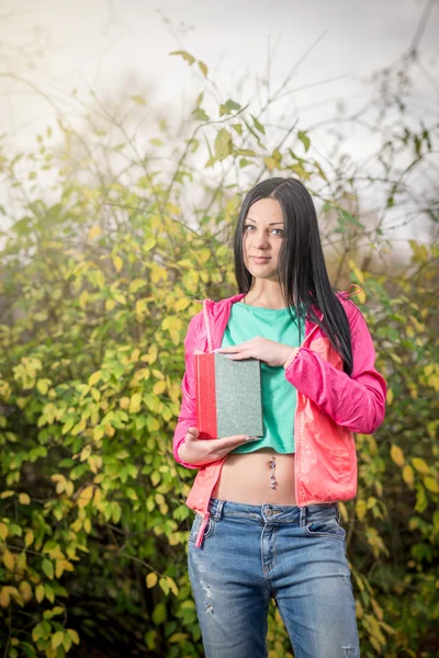 Menina no parque segurando livro — Fotografia de Stock