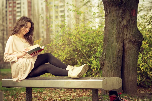 Fille lisant un livre dans le parc — Photo