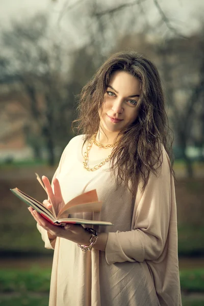 Fille lisant un livre dans le parc — Photo