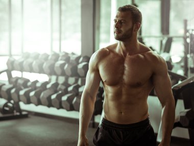 Genç adam spor salonunda poz