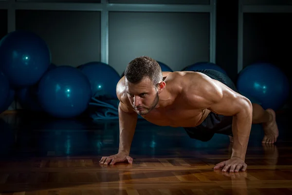 Man gör armhävningar i gym — Stockfoto