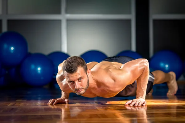 Hombre haciendo flexiones en el gimnasio — Foto de Stock