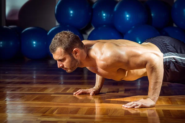 Man doing push-ups in gym — Stock Photo, Image