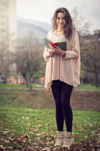 Fille lisant un livre dans le parc — Photo