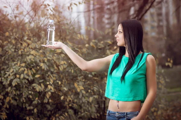 Flicka med flaska vatten i park — Stockfoto