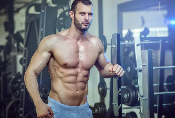 Homme posant dans la salle de gym montrant abdos — Photo