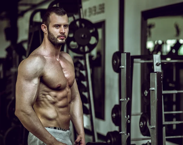 Hombre mostrando abdominales en el gimnasio — Foto de Stock