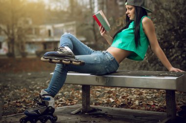 Kız kot pantolon tezgah üzerine bir kitap okuma