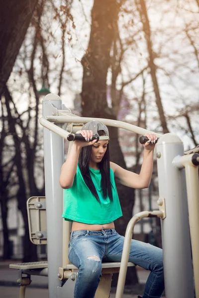 Chica haciendo hombro prensa al aire libre — Foto de Stock