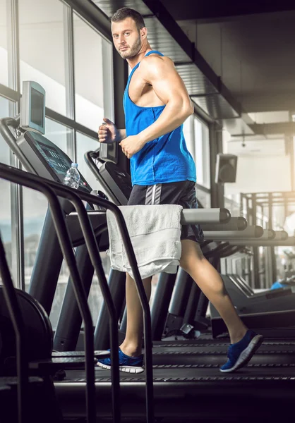 年轻人在健身房的跑步机运行 — Stockfoto