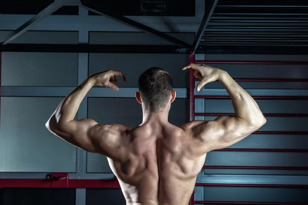 Man posing in gym showing back — Stock Photo, Image