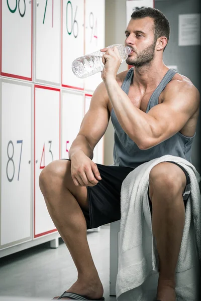 Man drinking water in locker room