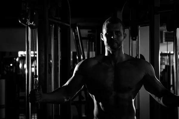 Silhouette of man doing cable fly in gym — 图库照片