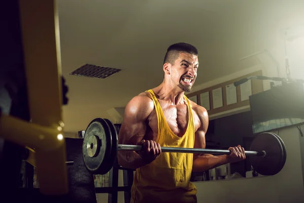Young man doing barbell exercise in gym — Stock Photo, Image