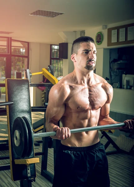 Jovem fazendo exercício de barbell no ginásio — Fotografia de Stock