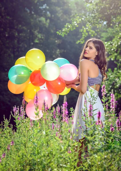 Chica sosteniendo globos en la mano —  Fotos de Stock