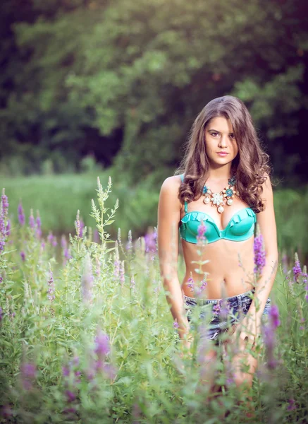 Meisje permanent in gras op de rivier bank — Stockfoto