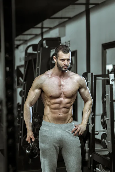 Homem posando no ginásio mostrando abdominais — Fotografia de Stock