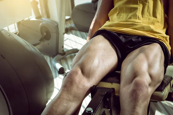 Man doing leg extension in gym — Stock Photo, Image